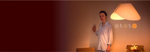 "Mujer ajustando la iluminación LED con el interruptor de pared, mostrando el cálido ambiente de la gran lámpara LED y las opciones de brillo personalizables en un acogedor dormitorio".
