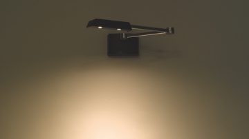 Een verstelbare lamp die op een wand gericht is