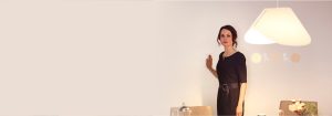 “女人通过光滑的壁挂式调光器调节明亮的 LED 嵌入式照明，增强了现代客厅的氛围和能效。”