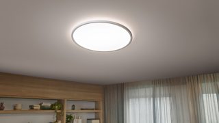 Le lampadine a filamento LED di ispirazione vintage appese come luci pendenti creano un'atmosfera calda in un'accogliente sala da pranzo, presentando soluzioni di illuminazione domestica eleganti e a risparmio energetico