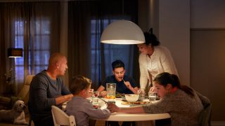 La gran luminaria LED colgante ilumina la mesa familiar, creando un ambiente cálido para las cenas y mostrando soluciones de iluminación superior energéticamente eficientes para los hogares modernos