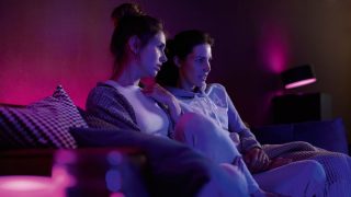Philips Hue smarta LED-lampor skapar en livfull lila och rosa atmosfär i vardagsrummet och visar anpassningsbar stämningsbelysning för filmkvällar och avkoppling i moderna hem.