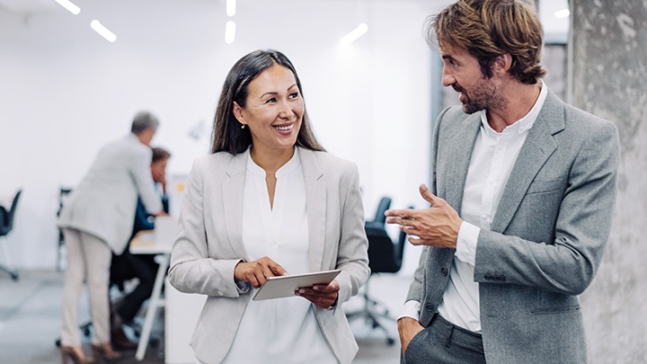 Businessman and businesswoman using digital tablet in modern office