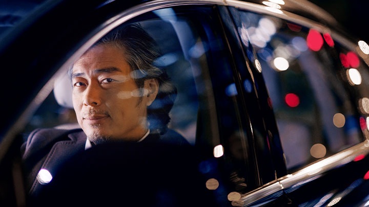 A business person in a car at night smiling