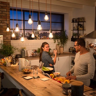 Pari juttelee Philips Vintage LED-lampun alla joka luo viihtyis&auml;n l&auml;mpim&auml;n hehkun
