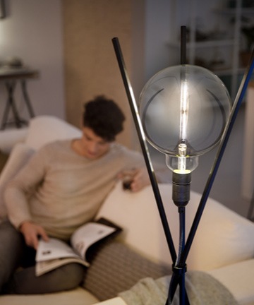 Mies lukee modernin Philips LED-lampun vieress&auml;