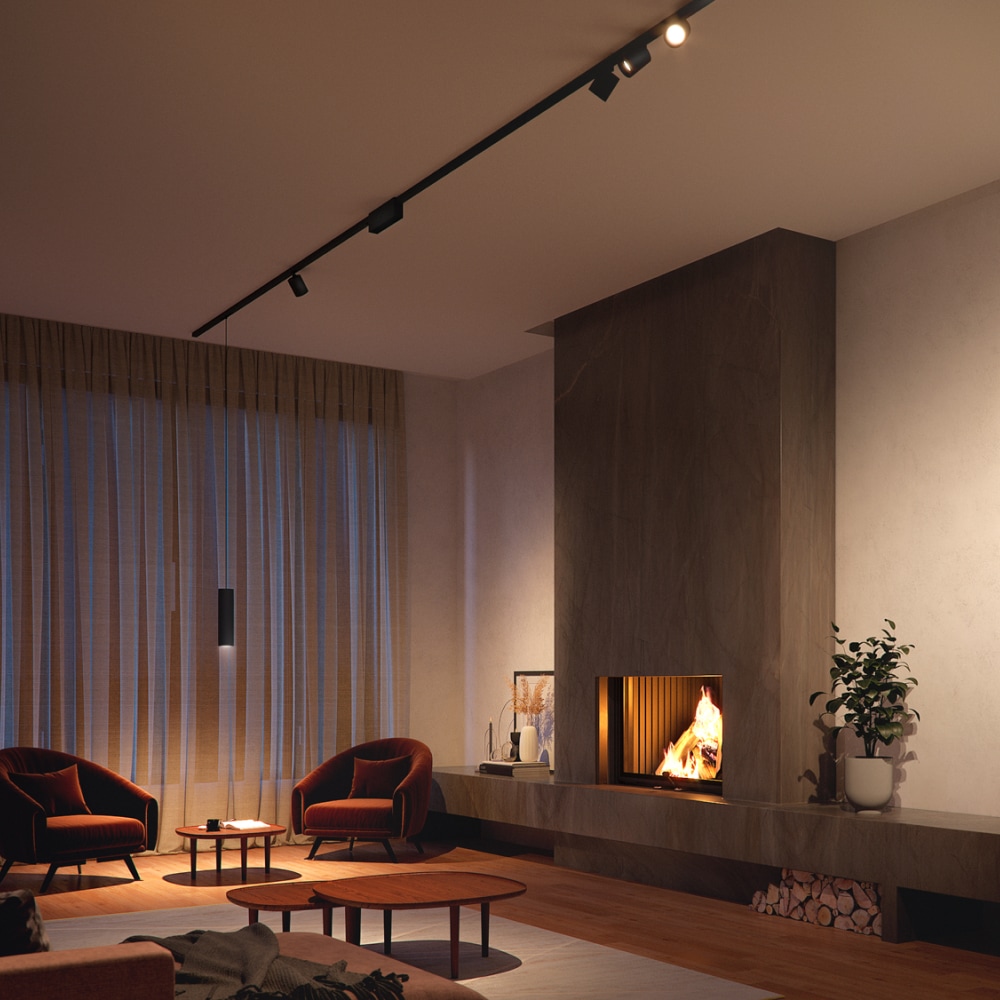 Ceiling-mounted black track lighting system illuminating a modern living room with a fireplace, seating area, and large windows.