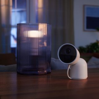 Caméra de sécurité sur une table à côté de la lampe intelligente