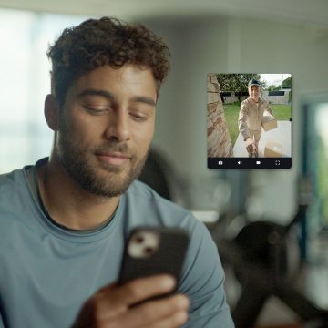 Un homme voit un livreur devant sa porte d'entrée sur son smartphone via l'application Hue.