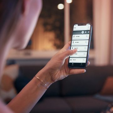 Femme tenant un téléphone montrant l'application Smart Light