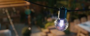 Un globe Lightguide sur une guirlande extérieure Festavia émanant une lumière rose clair. 