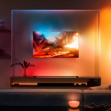 Samsung-tv hangend aan de muur in de woonkamer omgeven door gekleurde lampen 