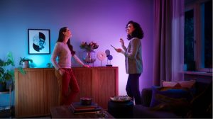 Twee vrouwen in een woonkamer die is verlicht met zachte tinten blauw en paars slim licht,
