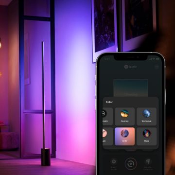 Lampe sur pied intelligente avec appareil mobile affichant la galerie de scènes Hue de l'application Hue