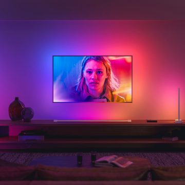 LG TV som sitter på väggen i vardagsrummet omgiven av färgglada lampor 