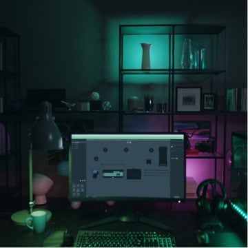 Närbild på ett gamingskrivbord med färgglad, svagt upplyst bakgrund