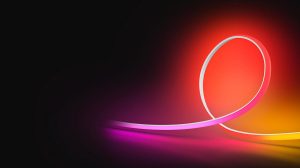 En OmniGlow LED-list som lyser i rosa, rött och gult ljus mot en svart bakgrund. 