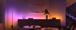 Living room with soft ambient glow from smart under cabinet lighting in purple and orange, highlighting modern decor and artwork.