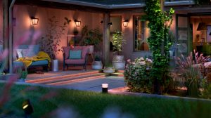 Outdoor smart lights installed along garden steps and mounted on walls, illuminating seating area and plants in the backyard.