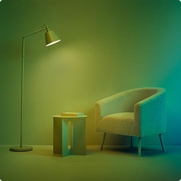 Una de las bombillas LED WiZ que proyecta un color verde vibrante en una sala de estar.
